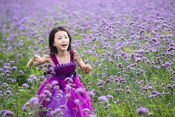 快乐的小女孩在花海里奔跑图片