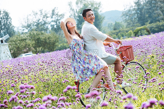 青年夫妇在花海里骑车图片