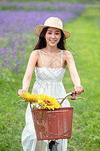 青年女人在花海里骑自行车图片