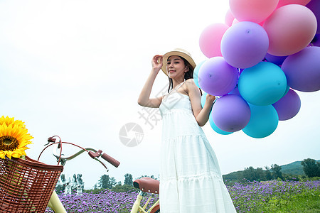 青年女人在花海里拿着气球图片