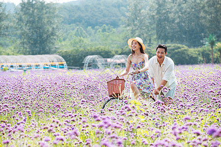 青年夫妇在花海里骑车图片