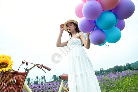 青年女人在花海里拿着气球图片