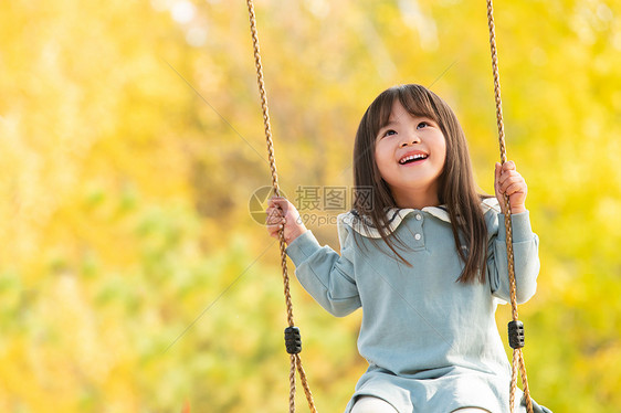 在公园里荡秋千的快乐女孩图片