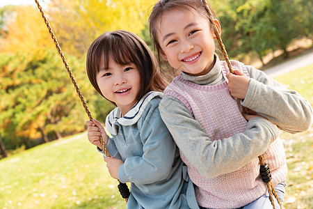 两个女孩在公园里荡秋千图片