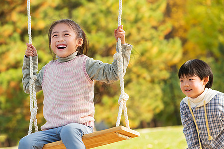 在公园里荡秋千的快乐儿童图片