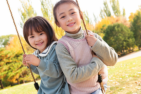 两个女孩在公园里荡秋千图片