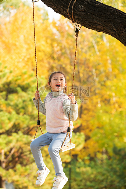 快乐的小女孩在公园里荡秋千图片