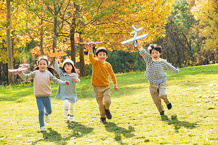 快乐儿童拿着玩具飞机在公园玩耍图片