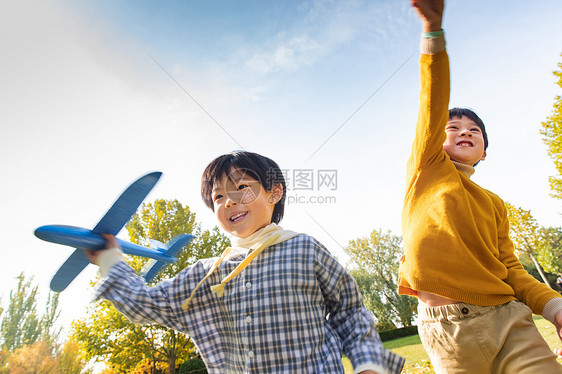 拿着玩具飞机在公园玩耍的男孩图片