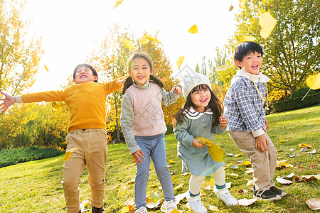 欢乐儿童在公园里玩树叶高清图片