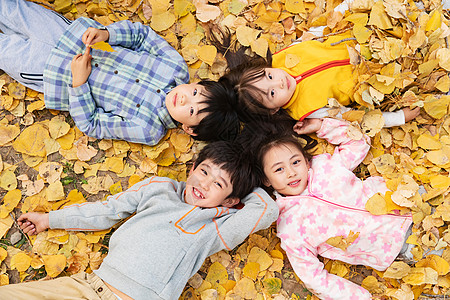 北京秋天可爱的小朋友们躺在草地上玩耍背景