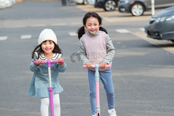 快乐的小女孩在户外玩滑板车图片