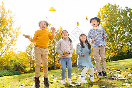 快乐的小朋友们在公园里玩树叶图片