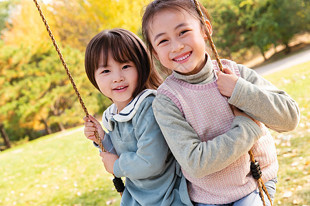 两个女孩在公园里荡秋千图片