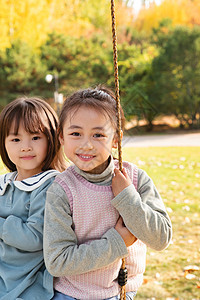 两个女孩在公园里荡秋千图片