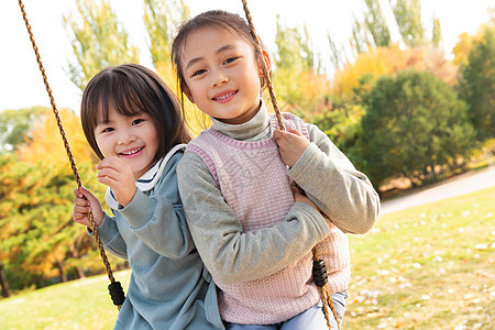 两个女孩在公园里荡秋千图片