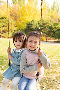 两个女孩在公园里荡秋千图片