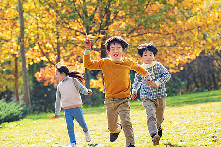 拿着玩具飞机在公园玩耍的快乐儿童图片