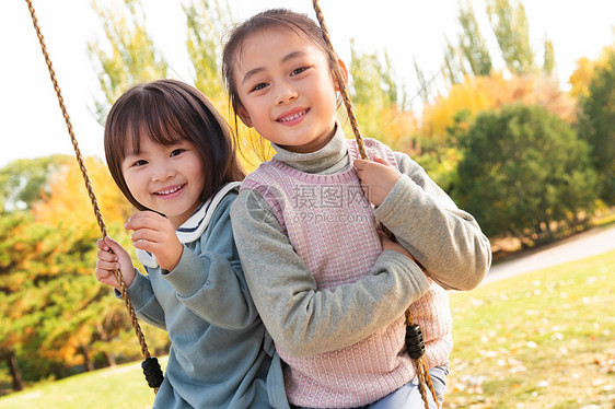 两个女孩在公园里荡秋千图片