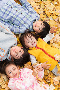 可爱的小朋友们躺在落叶上玩耍图片