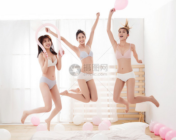 闺蜜在卧室拿着气球玩耍跳跃图片