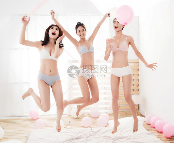 闺蜜在卧室拿着气球玩耍跳跃图片