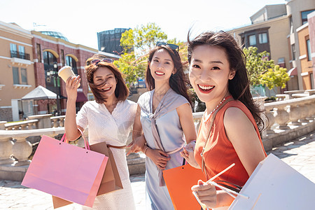 快乐的青年女人和闺蜜逛街购物图片