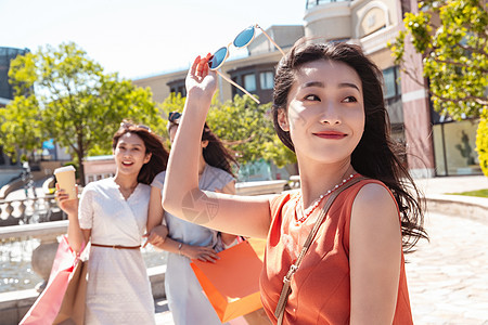 快乐的青年女人和闺蜜逛街购物图片