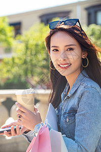 青年女人拿着手机逛街图片