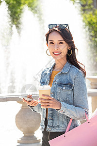 青年女人拿着手机逛街图片