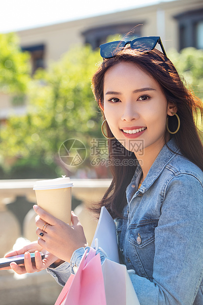 青年女人拿着手机逛街图片