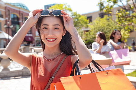 快乐的青年女人和闺蜜逛街购物图片