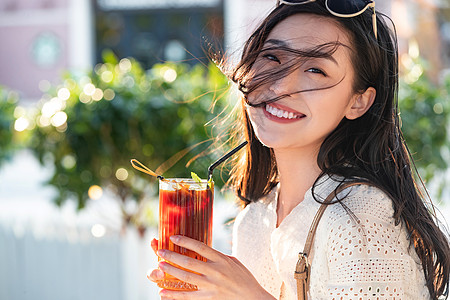 快乐的青年女人拿着夏日饮品图片