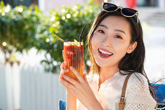 快乐的青年女人端着夏日饮品图片