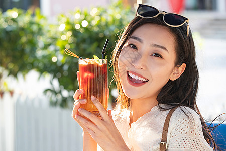 摄影快乐的青年女人端着夏日饮品背景