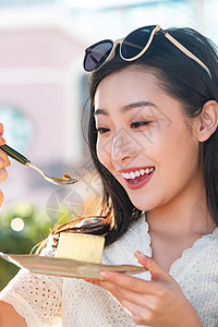 品尝芝士蛋糕的快乐青年女人图片