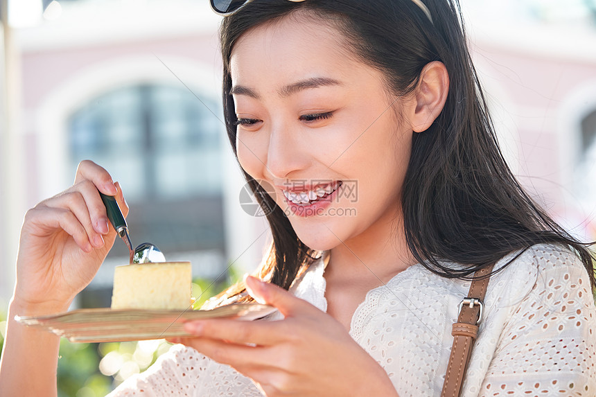 品尝芝士蛋糕的快乐青年女人图片