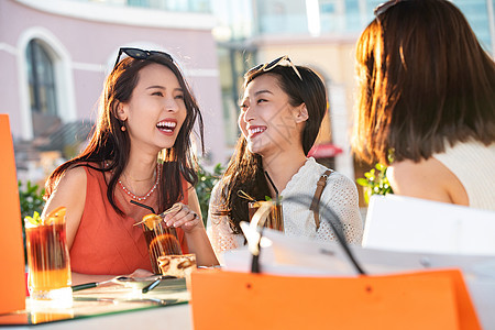 漂亮年轻的女孩们坐在露天咖啡馆聊天图片