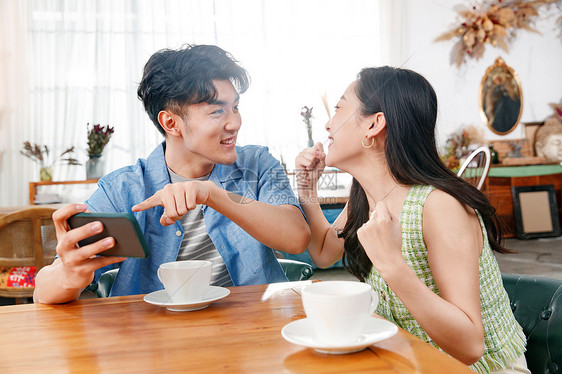 青年情侣在家玩手机图片