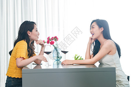 年轻闺蜜坐在一起喝红酒图片