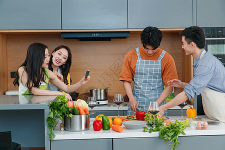 快乐的年轻人在厨房做饭照相图片