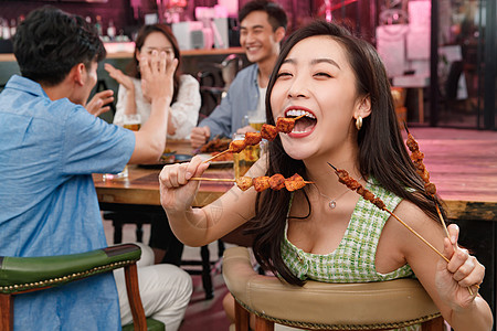 夜店啤酒青年女人和朋友一起吃烧烤背景