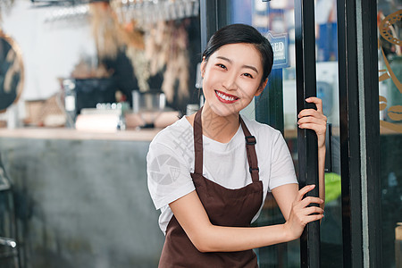 咖啡店门口迎接顾客的女服务员图片