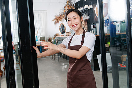 咖啡店门口迎接顾客的女服务员图片