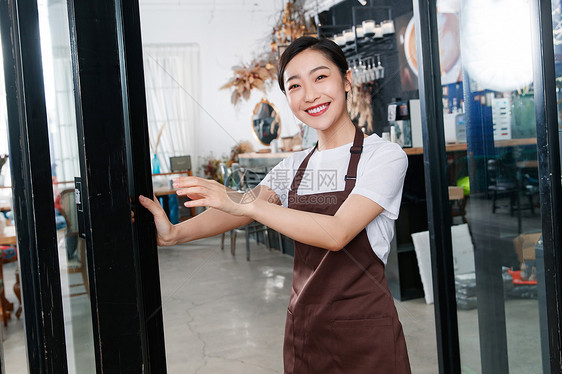 咖啡店门口迎接顾客的女服务员图片