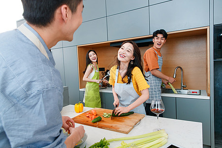 快乐的年轻人在厨房做饭图片