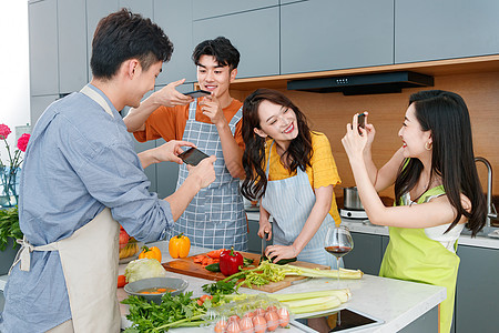 快乐的年轻人在厨房做饭照相图片