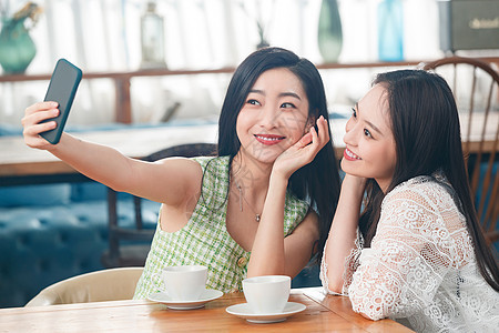 年轻闺蜜在咖啡馆聊天图片