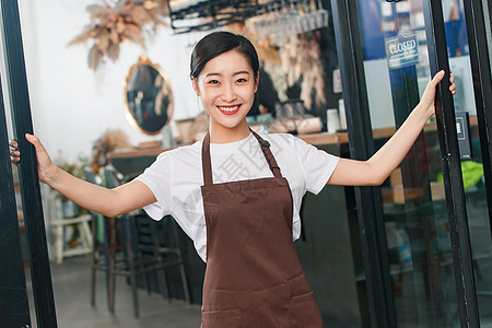 咖啡店门口迎接顾客的女服务员图片