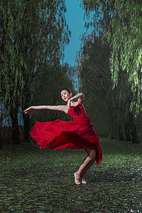 穿红色裙子的青年女人在户外跳芭蕾舞图片